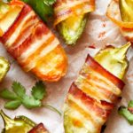 This bacon-wrapped low carb, Keto Jalapeno Poppers recipe doubles as a savory fat bomb and appetizer. Perfect for game day or the holidays, you can make this easy keto recipe with cream cheese and cheddar cheese in the air fryer, grill or oven! You don’t have to be on a low carb ketogenic diet to love these bacon wrapped Jalapeno poppers! #jalapeno #jalapenopoppers #lowcarb #lowcarbjalapenonpoppers #keto #ketorecipes