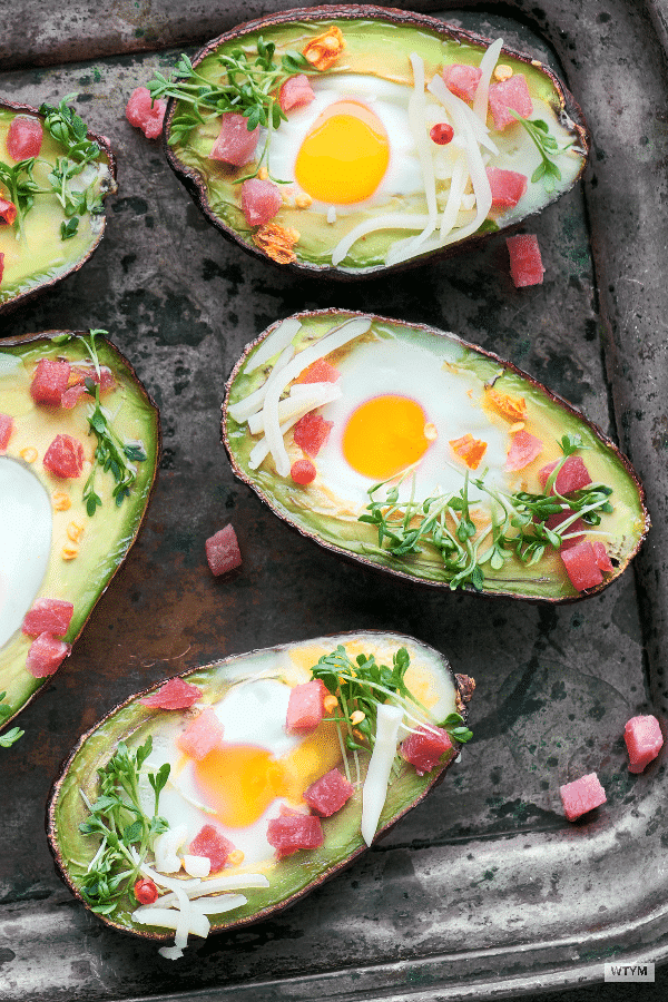 Avocado Baked Eggs are an easy and quick low carb, keto breakfast idea that you can put together using three simple ingredients. Egg stuffed avocados are a filling, high protein breakfast that’s clean eating, Paleo and Whole30 approved with 4 WW SmartPoints. #keto #ketorecipes #lowcarbrecipes #breakfast #avocado #eggs #breakfastrecipes #paleobreakfast #wwbreakfast