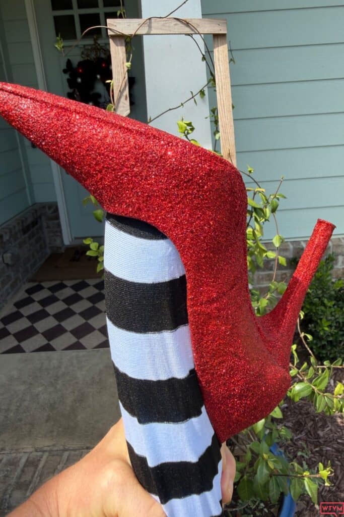 Close-up of a thrift store high heel covered in red glitter to look like Dorothy's ruby slippers